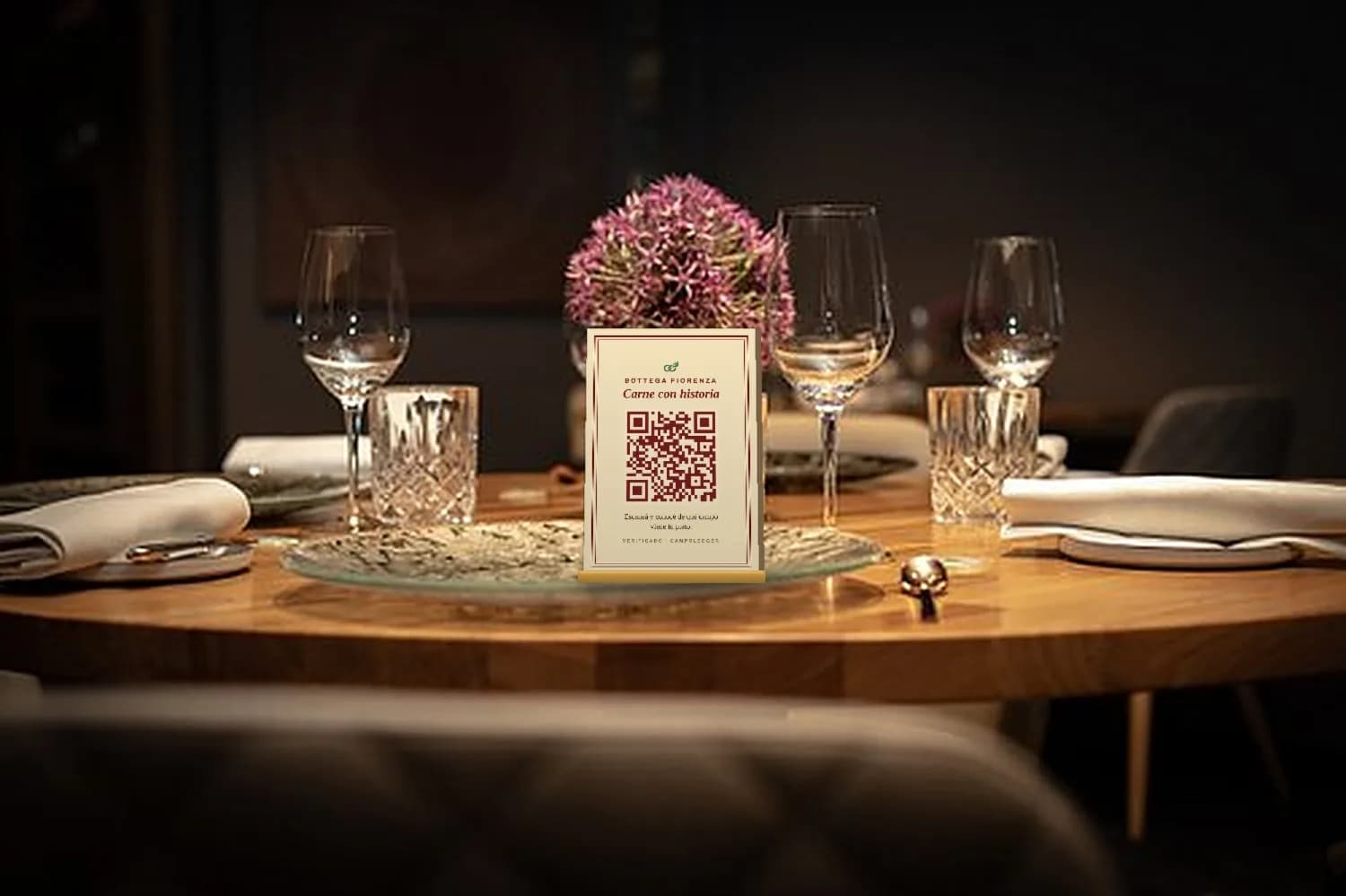 Mesa de restaurante con una tarjeta con QR de CampoLedger en el centro, junto a las flores